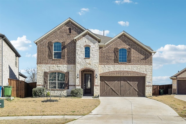 french country inspired facade with a garage, fence, brick siding, and driveway