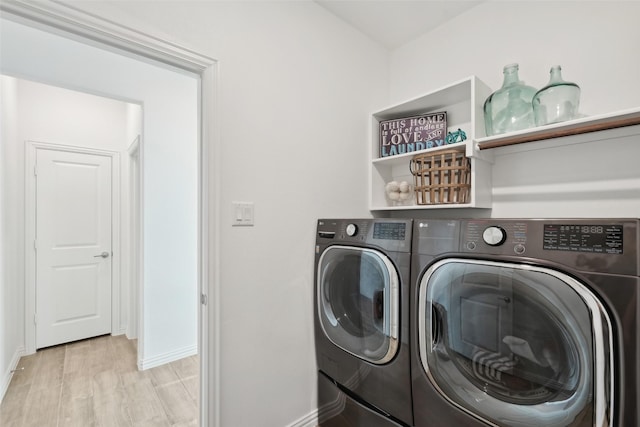 laundry area with baseboards, wood finished floors, laundry area, and washer and clothes dryer