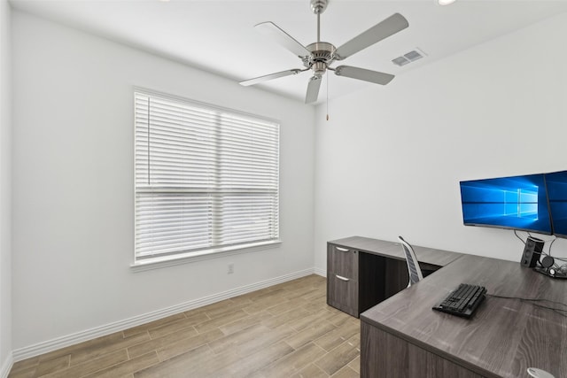 office area with ceiling fan, baseboards, visible vents, and light wood-type flooring