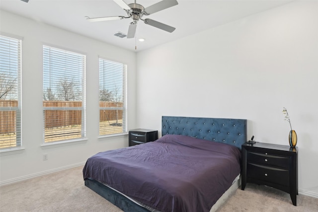 carpeted bedroom with visible vents, a ceiling fan, and baseboards