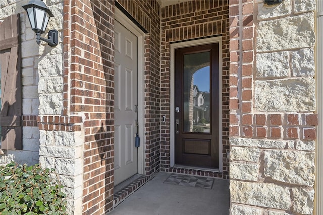 doorway to property with brick siding