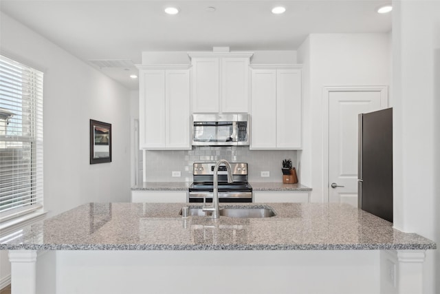 kitchen featuring white cabinetry, decorative backsplash, visible vents, and appliances with stainless steel finishes