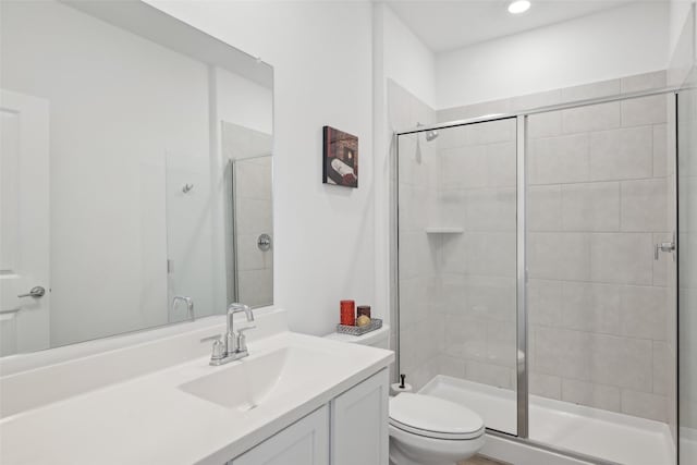 full bathroom featuring a shower stall, toilet, and vanity