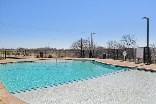 pool with a patio area and fence