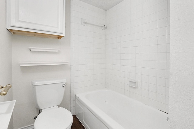 bathroom featuring tiled shower / bath combo and toilet