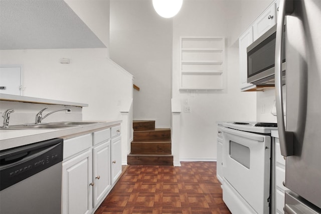 kitchen with appliances with stainless steel finishes, sink, white cabinetry, a textured ceiling, and dark parquet floors