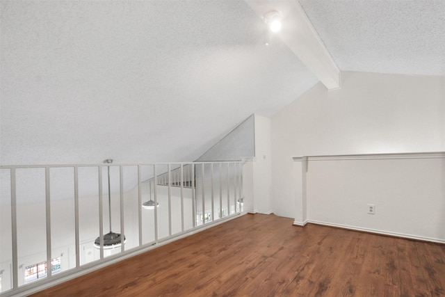 bonus room featuring dark wood-type flooring, lofted ceiling with beams, and a textured ceiling