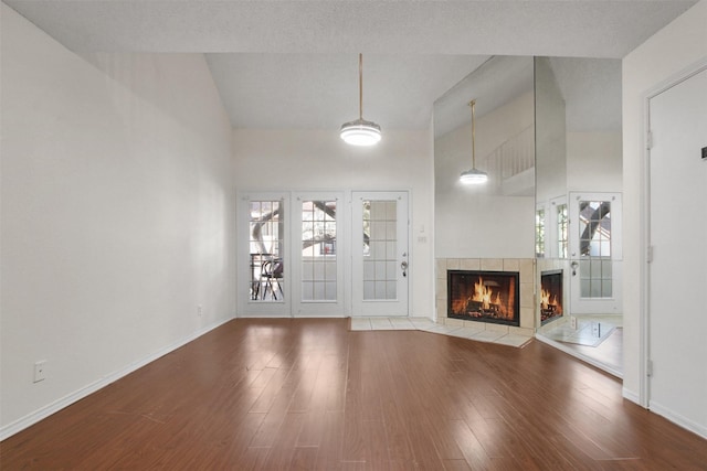 unfurnished living room featuring a fireplace, high vaulted ceiling, and wood-type flooring