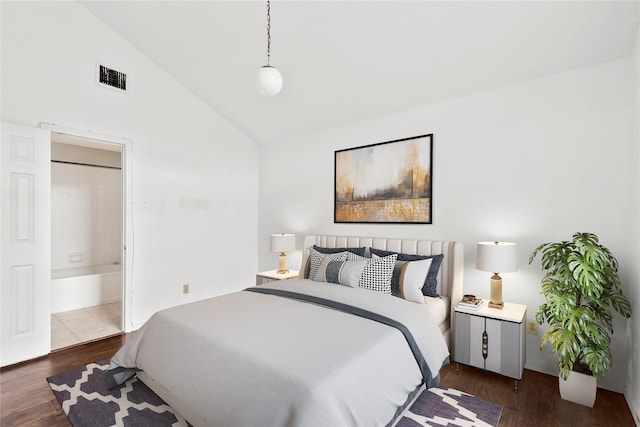 bedroom featuring vaulted ceiling, dark hardwood / wood-style floors, and connected bathroom