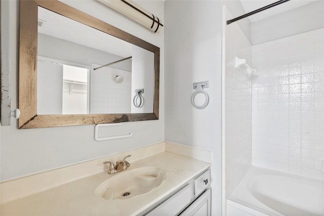 bathroom featuring tiled shower / bath combo and vanity