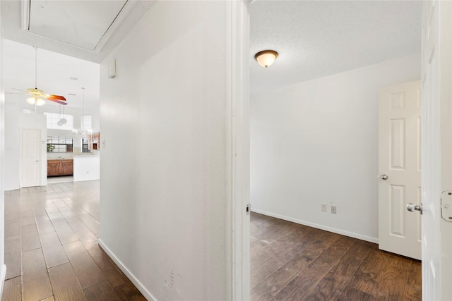 hallway with hardwood / wood-style flooring and a textured ceiling