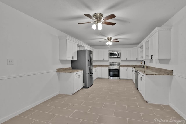 10553 White Oak Dr, Keithville, LA 71047 - kitchen with sink, ceiling fan, stainless steel appliances, light stone countertops, and white cabinets