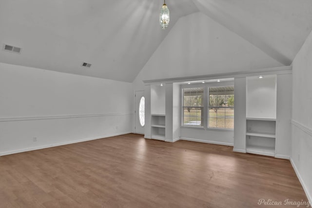 10553 White Oak Dr, Keithville, LA 71047 - unfurnished living room featuring a notable chandelier, built in features, wood-type flooring, and high vaulted ceiling