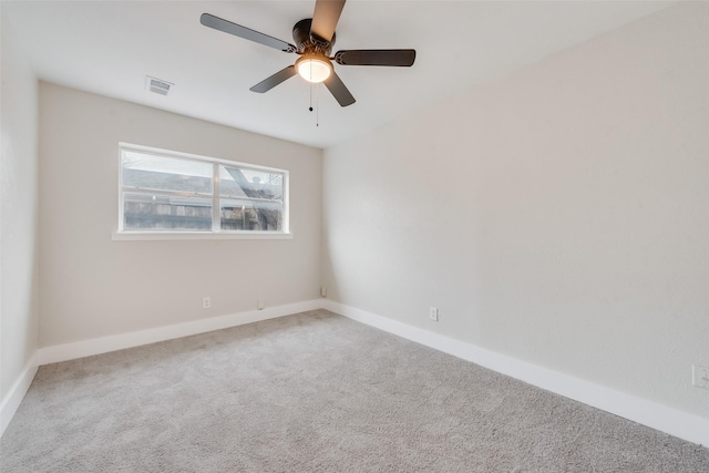 spare room with ceiling fan and carpet