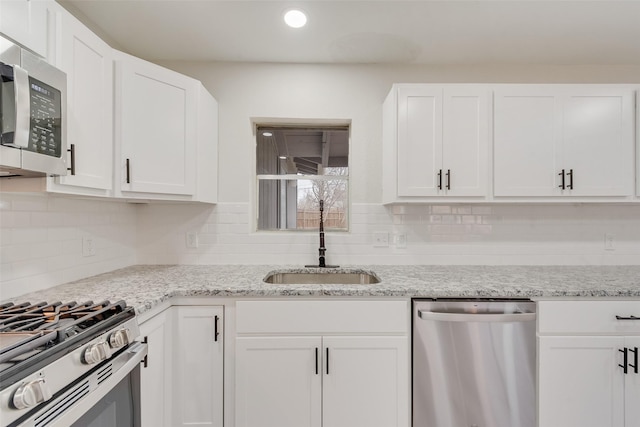 kitchen with stainless steel appliances, sink, and white cabinets