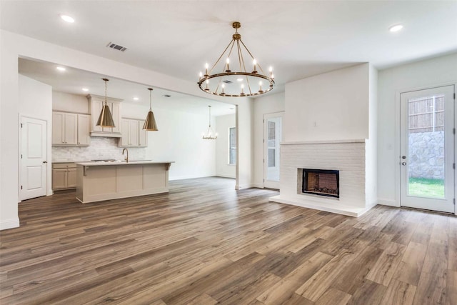 782 Sterling Dr, Benbrook, TX 76126 - unfurnished living room with a chandelier, wood finished floors, healthy amount of natural light, a fireplace, and recessed lighting