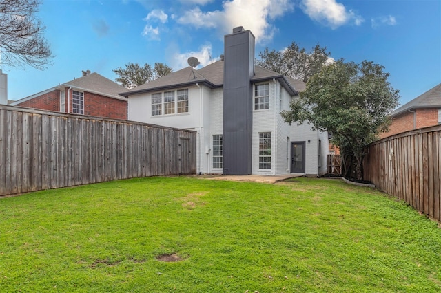 rear view of property with a yard