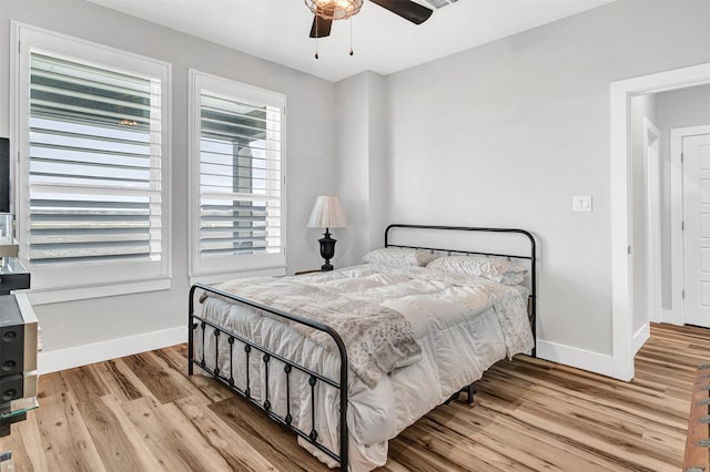 bedroom featuring baseboards, ceiling fan, and light wood-style floors