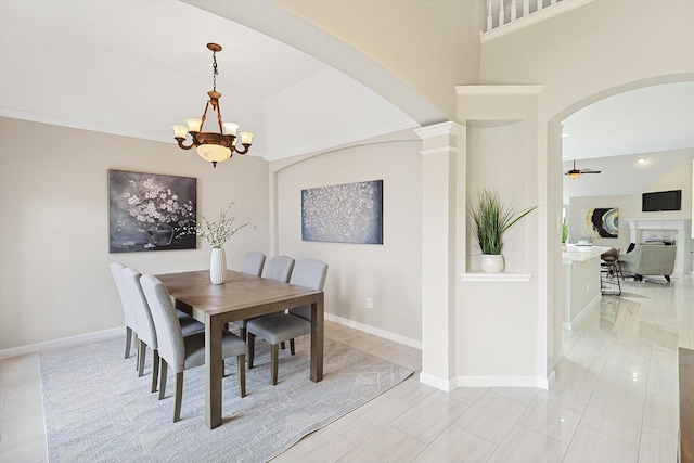 dining space featuring ceiling fan with notable chandelier and vaulted ceiling