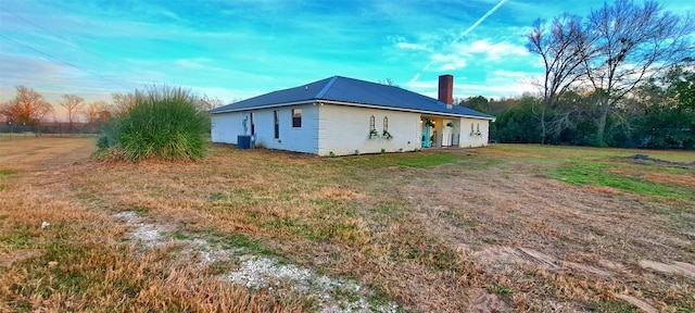 view of side of home with a yard and central air condition unit