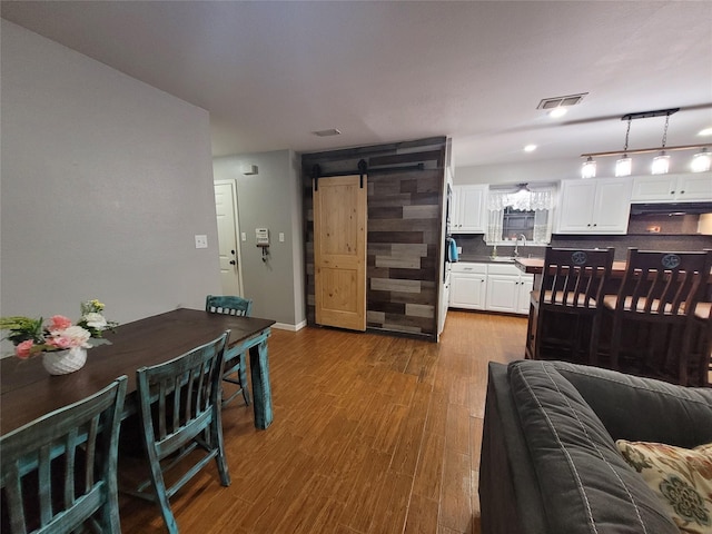 interior space featuring wood-type flooring, a barn door, and sink