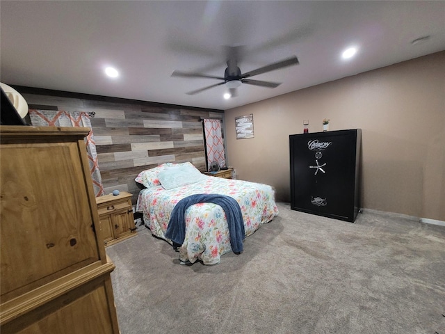 bedroom with wooden walls, light colored carpet, and ceiling fan