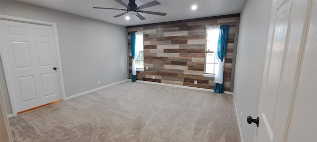 unfurnished bedroom featuring light carpet and wooden walls