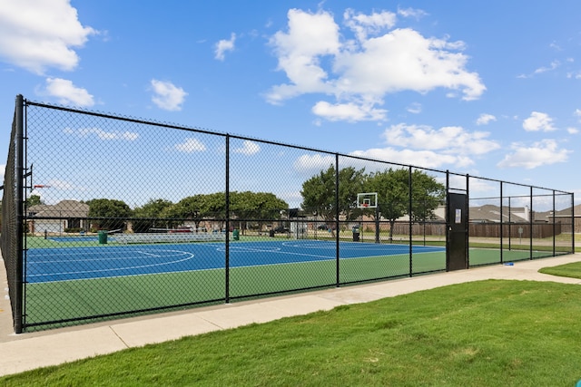 view of basketball court featuring a tennis court, community basketball court, fence, and a lawn