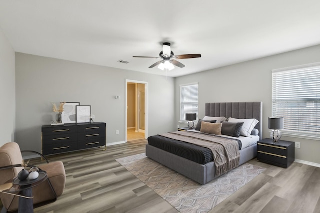 bedroom featuring multiple windows, ceiling fan, and light wood-type flooring