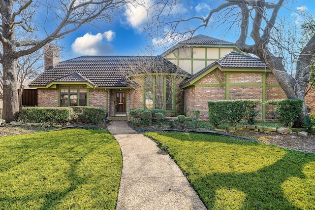 english style home featuring a front lawn