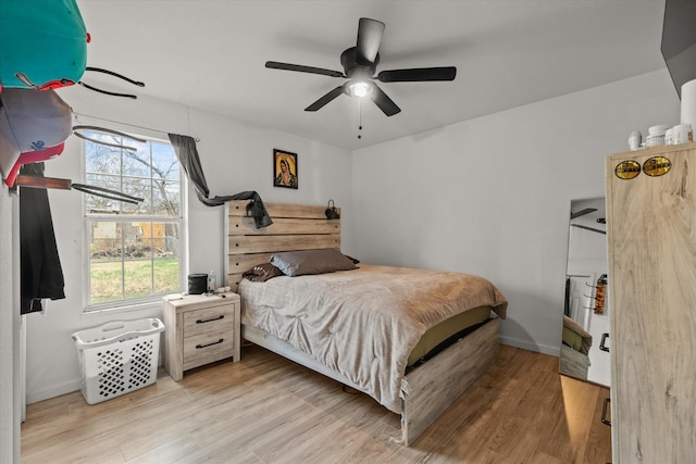 bedroom featuring ceiling fan, multiple windows, and light hardwood / wood-style flooring