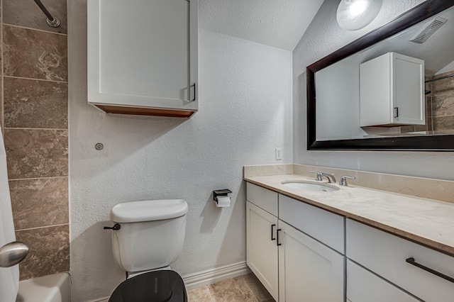 full bathroom with vanity, tiled shower / bath, and toilet