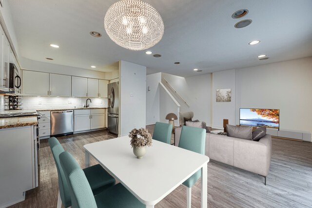 2722 Knight St Unit 316C, Dallas, TX 75219 - dining space with a chandelier, wood finished floors, and recessed lighting