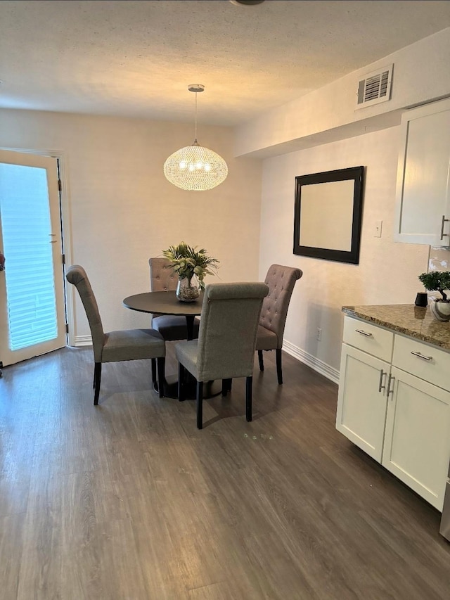 2722 Knight St Unit 316C, Dallas, TX 75219 - dining space featuring dark wood-type flooring, baseboards, and a chandelier