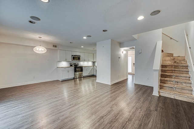 2722 Knight St Unit 316C, Dallas, TX 75219 - unfurnished living room with baseboards, wood finished floors, stairs, recessed lighting, and a textured ceiling