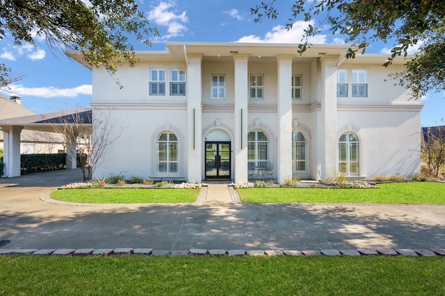 rear view of house with a carport, a yard, and french doors