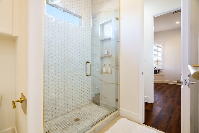 bathroom with hardwood / wood-style flooring and an enclosed shower