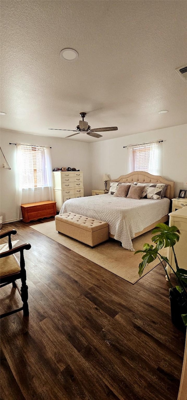 bedroom with hardwood / wood-style floors, a textured ceiling, and ceiling fan