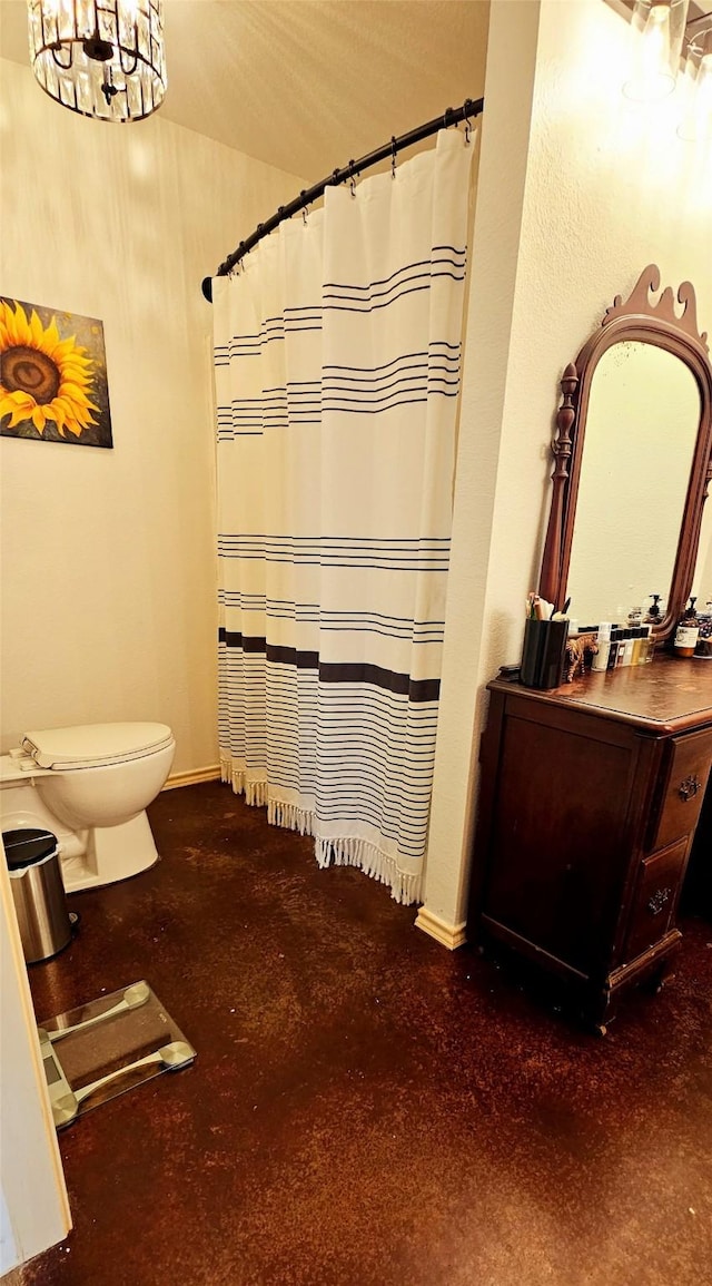 bathroom with a notable chandelier and toilet