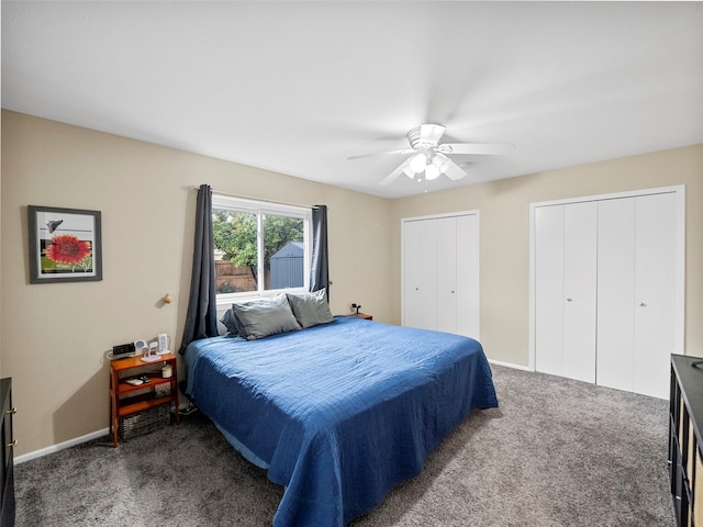 bedroom with two closets, ceiling fan, and dark colored carpet