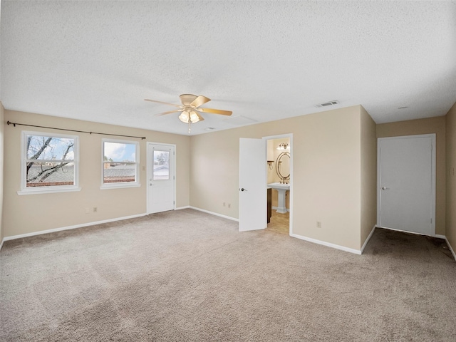 carpeted spare room with ceiling fan and a textured ceiling