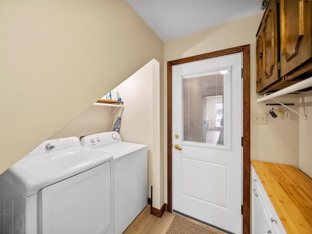 laundry room with cabinets, independent washer and dryer, and light hardwood / wood-style floors