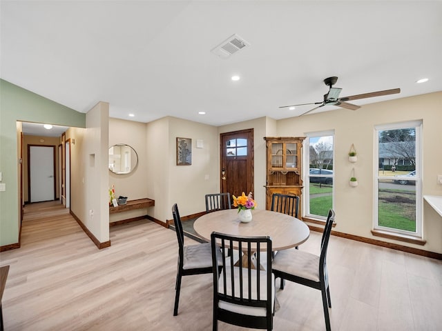 dining area with vaulted ceiling and light wood-type flooring