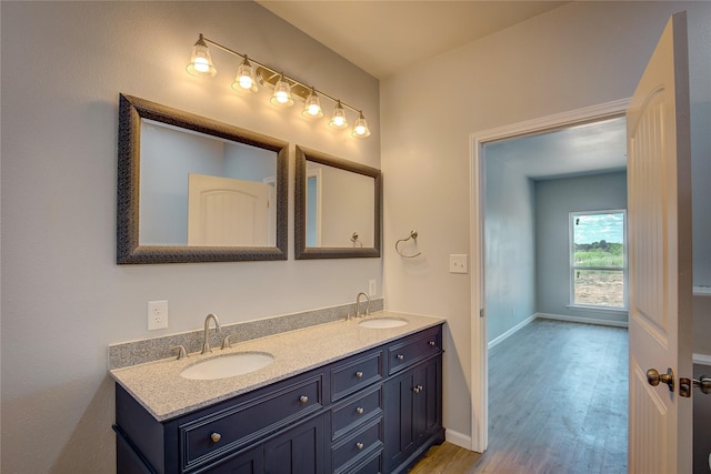 4340 Fm 1563, Wolfe City, TX 75496 - bathroom with double vanity, a sink, baseboards, and wood finished floors