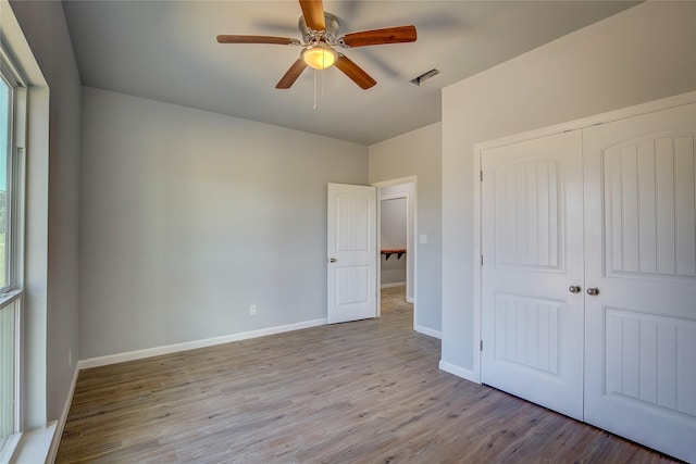 4340 Fm 1563, Wolfe City, TX 75496 - unfurnished bedroom featuring a closet, visible vents, baseboards, wood finished floors, and a ceiling fan