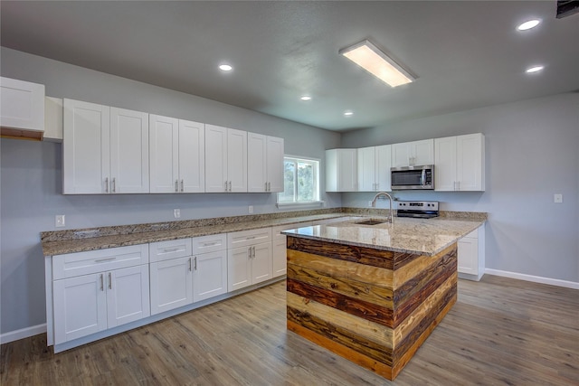 4340 Fm 1563, Wolfe City, TX 75496 - kitchen with white cabinets, wood finished floors, a sink, and stainless steel appliances
