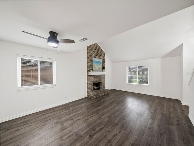 unfurnished living room with a fireplace, visible vents, baseboards, vaulted ceiling, and dark wood-style floors