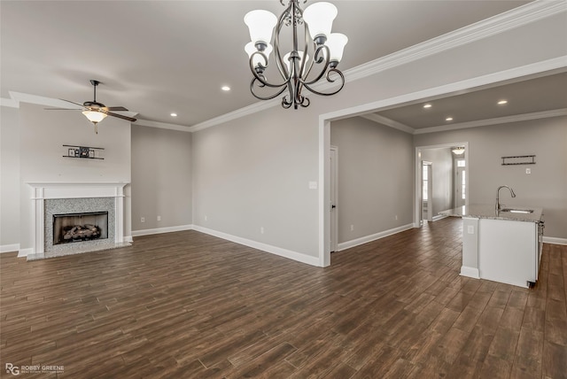 unfurnished living room featuring crown molding, sink, dark hardwood / wood-style floors, and ceiling fan with notable chandelier