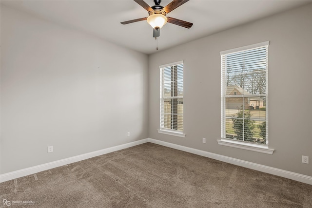 carpeted spare room featuring ceiling fan and a healthy amount of sunlight