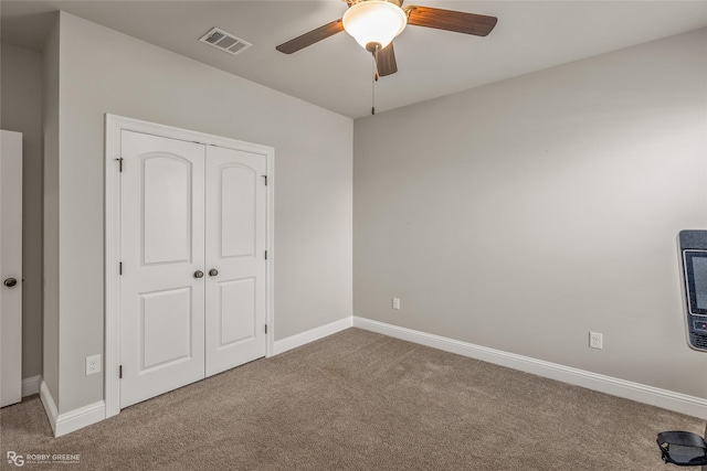 unfurnished bedroom with carpet, ceiling fan, and a closet